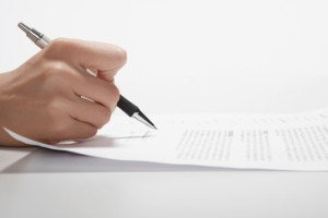 Woman's hand signing documents