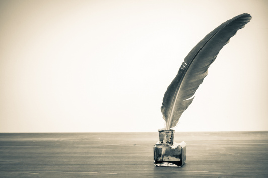 Vintage background with quill pen and inkwell on table